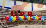 großer Schriftzug UPB in dem ein Mann steht, da drunter eine Girlande aus Luftballons