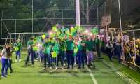 Große Gruppe von fröhlichen Menschen mit grünen T-shirts und Luftballons