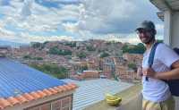 Ein Mann auf einem Balkon, im Hintergrund sieht man eine Stadt