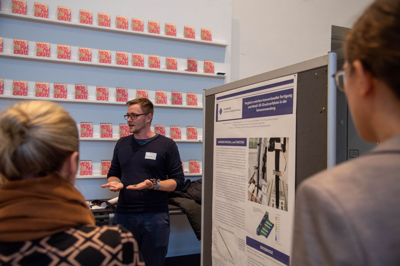 Personen hören einem Vortrag an einem Poster zu. (Foto: FH Münster/Michelle Liedtke)