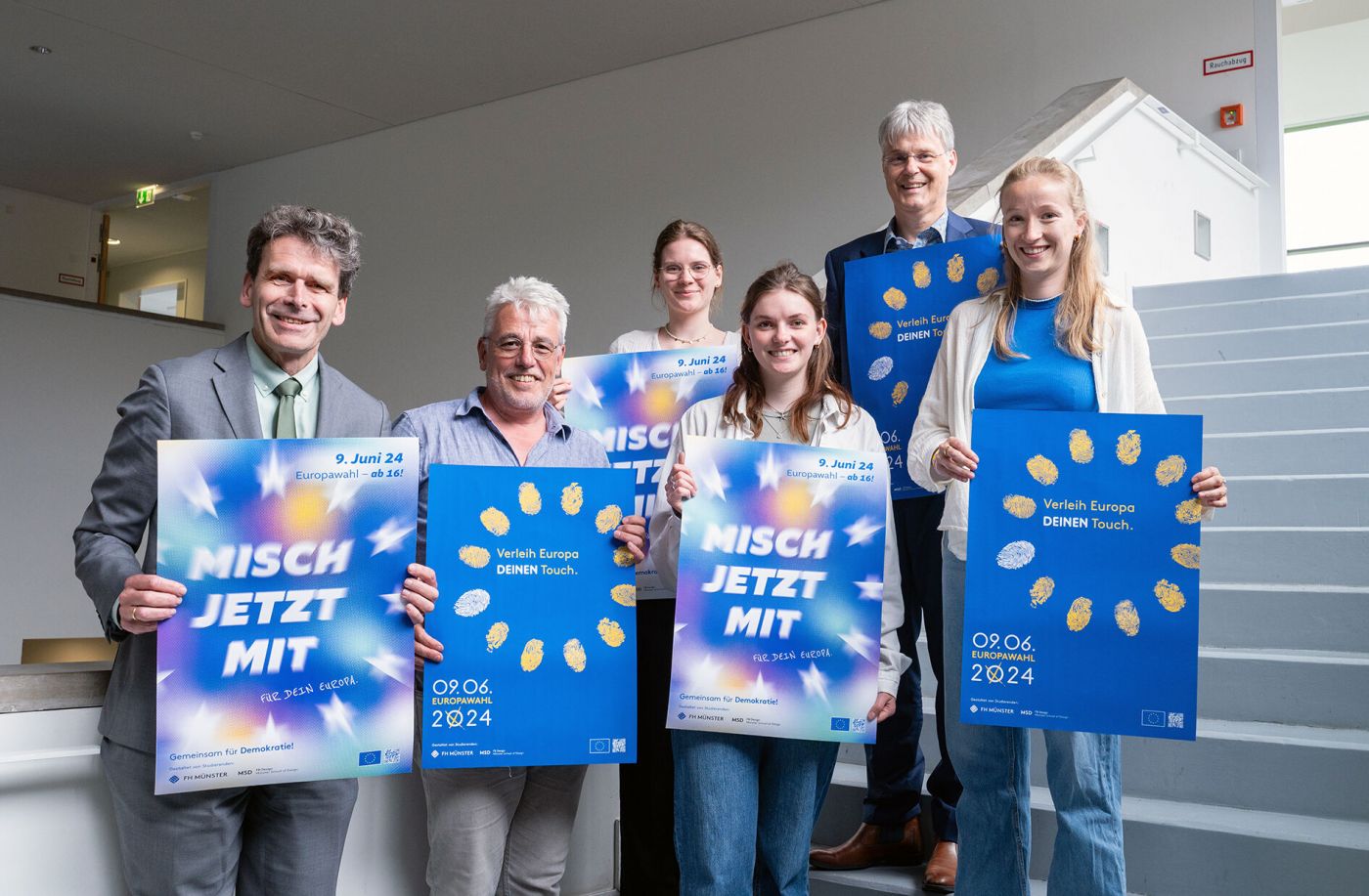 Eine Gruppe von Personen hält Plakate zur Europahlwahl 2024 in die Kamera, die dazu animieren sollen, wählen zu gehen. (Foto: FH Münster/Michelle Liedtke)