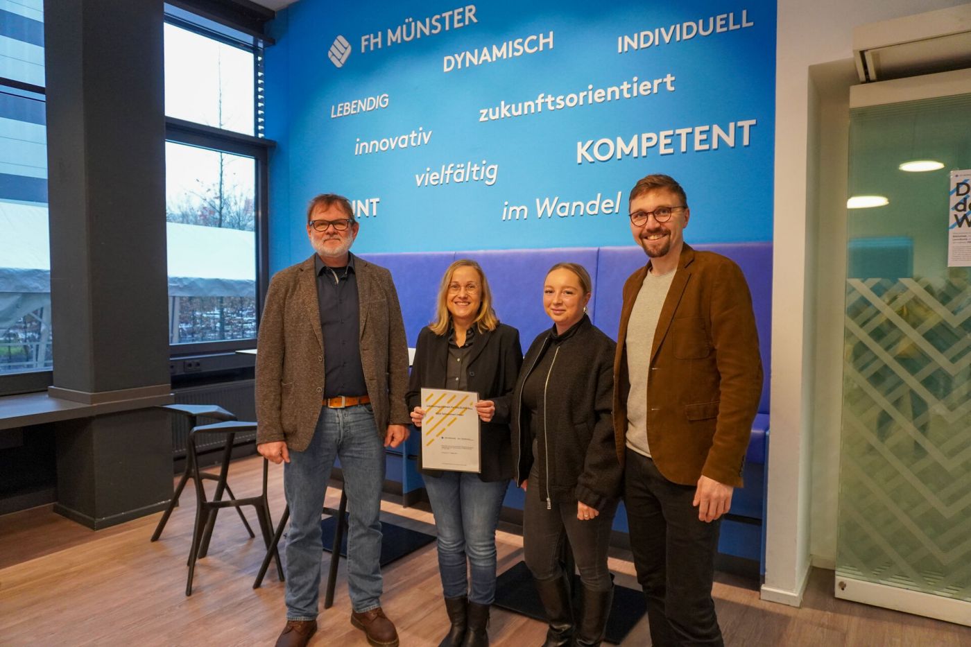 Vier Personen freuen sich, Eine Frau hält ein Zertifikat in der Hand (Foto: Foto: FH Münster/Lucie Golde)
