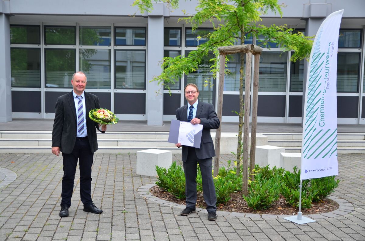 Prof. Dr. Thomas Jüstel (l.) gratuliert Dr. Ulrich Seifert (r.) zur verliehenen Honorarprofessur.  (Foto: FH Münster/Frederik Tebbe)