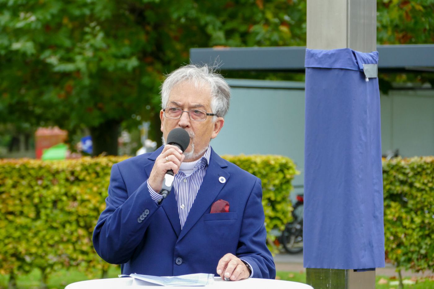 Mann hält Mikrofon in der Hand und steht am Stehtisch (Foto: FH Münster/Jana Bade)