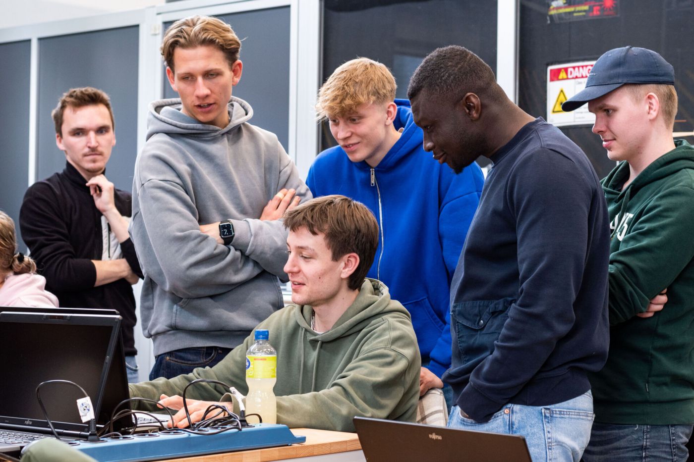 Das Foto zeigt mehrere Studenten, die gemeinsam auf den Bildschirm des Computers blicken. (Foto: FH Münster/Marina Oster)