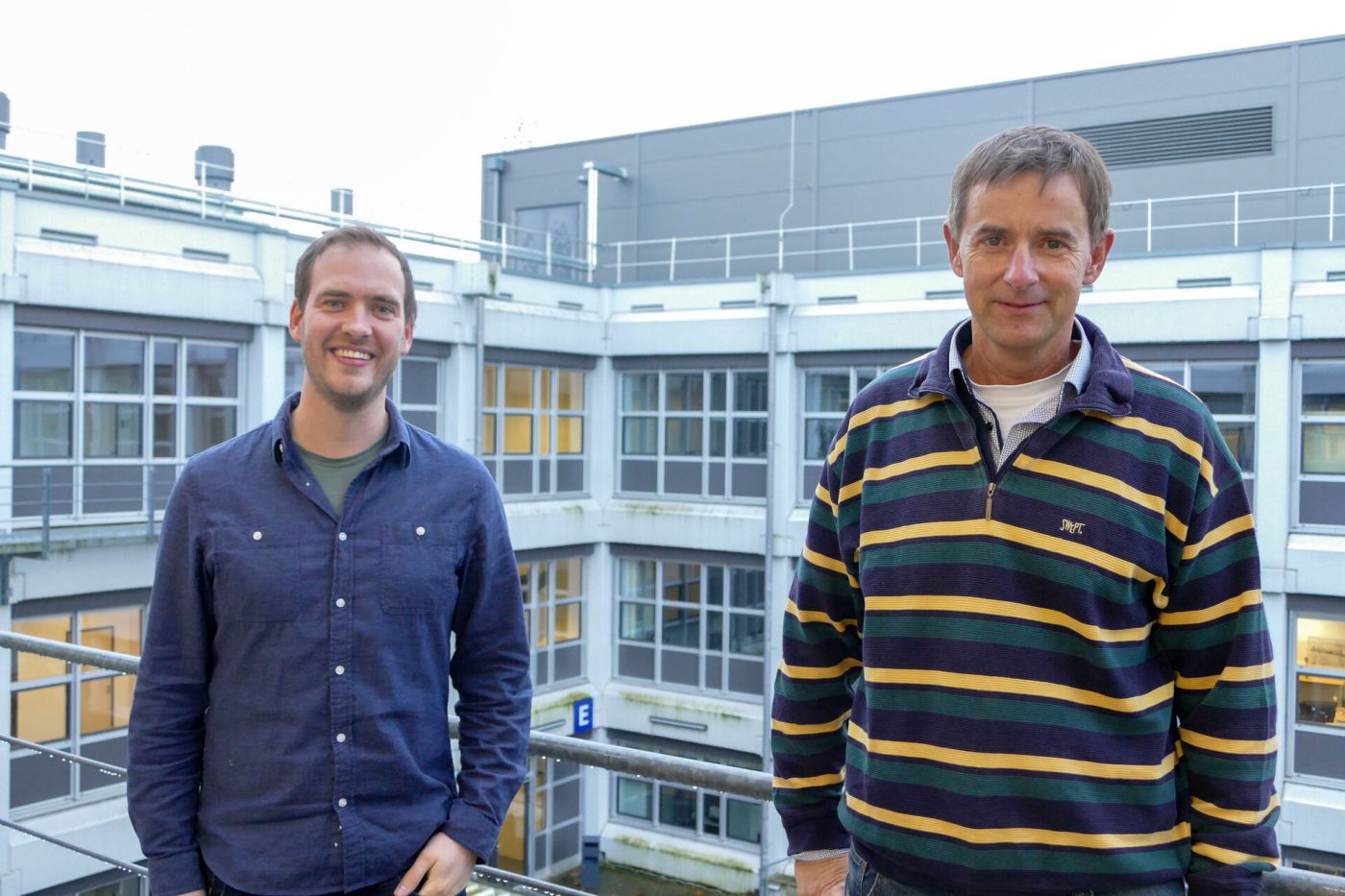 Prof. Dr. Peter Glösekötter und Andre Löchte stehen draußen vor einem Gebäude.  (Foto: FH Münster/Jana Schiller)