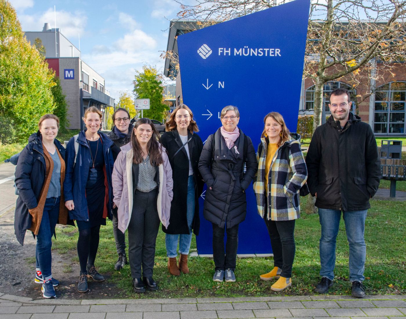 Sieben Frauen und ein Mann stehen auf einem Campusgelände. (Foto: FH Münster/Frederik Tebbe)