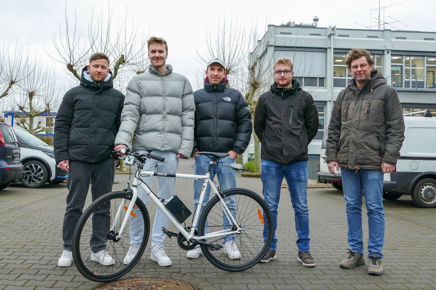 Fünf Männer stehen mit einem Fahrrad auf einem Parkplatz. (Foto: FH Münster/Jana Bade)