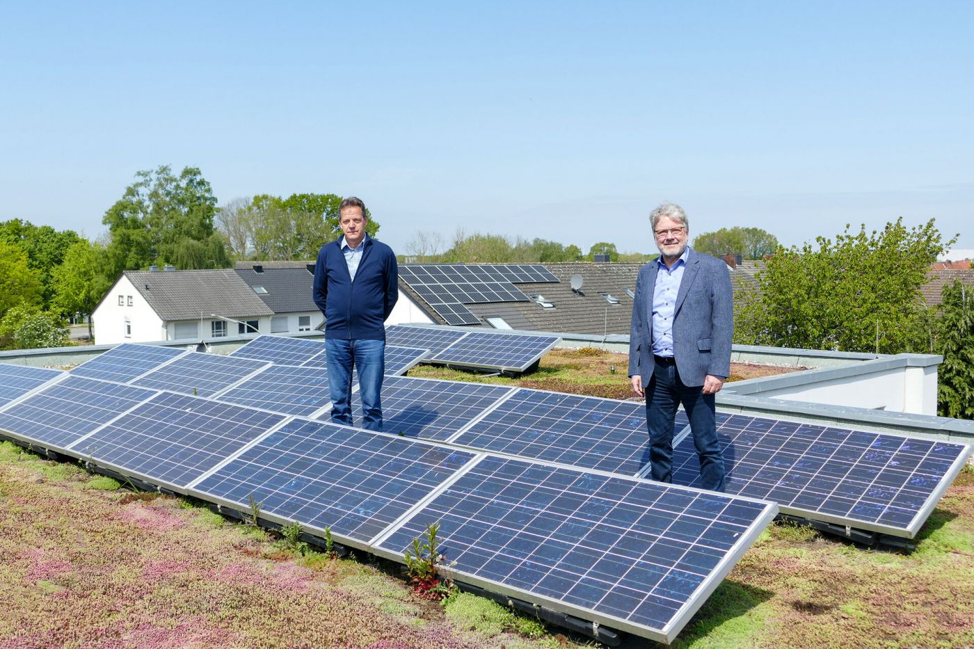 Zwei Männer stehen auf einem begrünten Dach mit Photovoltaikanlagen. (Foto: FH Münster/Jana Schiller)