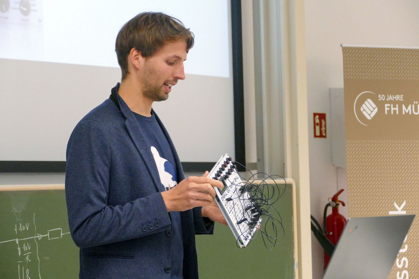 Dr. Sven Köppel hält den Analogrechner "The Analog Thing" in der Hand.  (Foto: FH Münster/Jana Schiller)