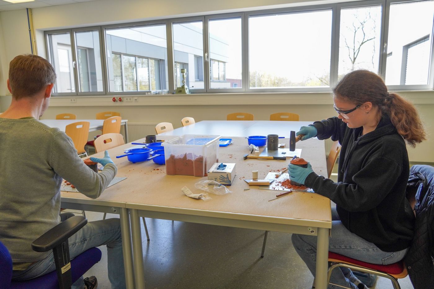 Ein Mann und eine Schülerin arbeiten zusammen in einem Labor.