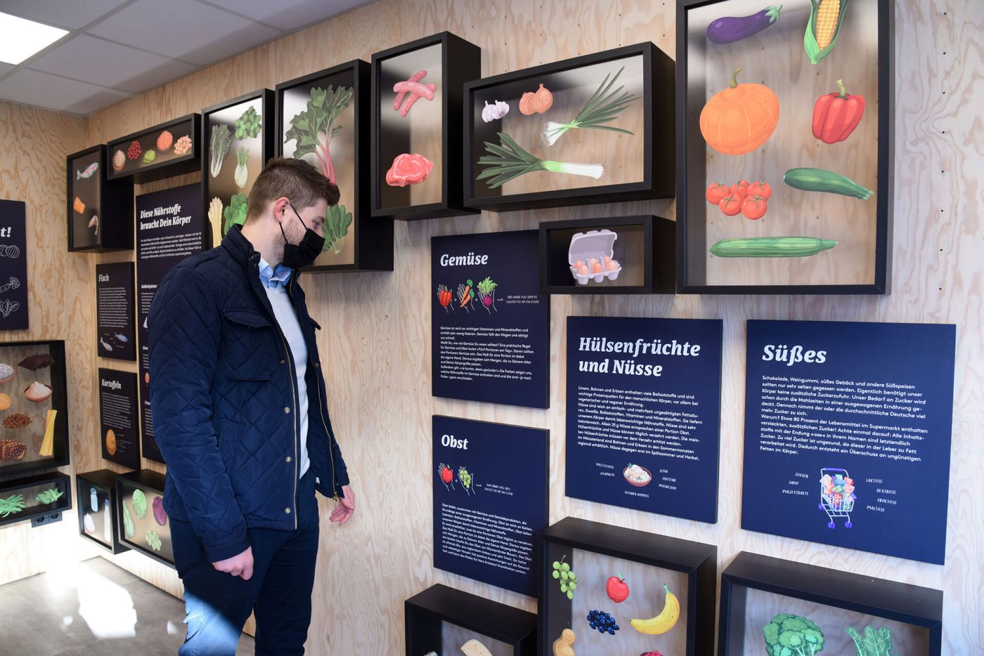 Ein Mann schaut sich eine Ausstellung zu gesunder Ernährung an. (Foto: FH Münster/Michelle Liedtke)