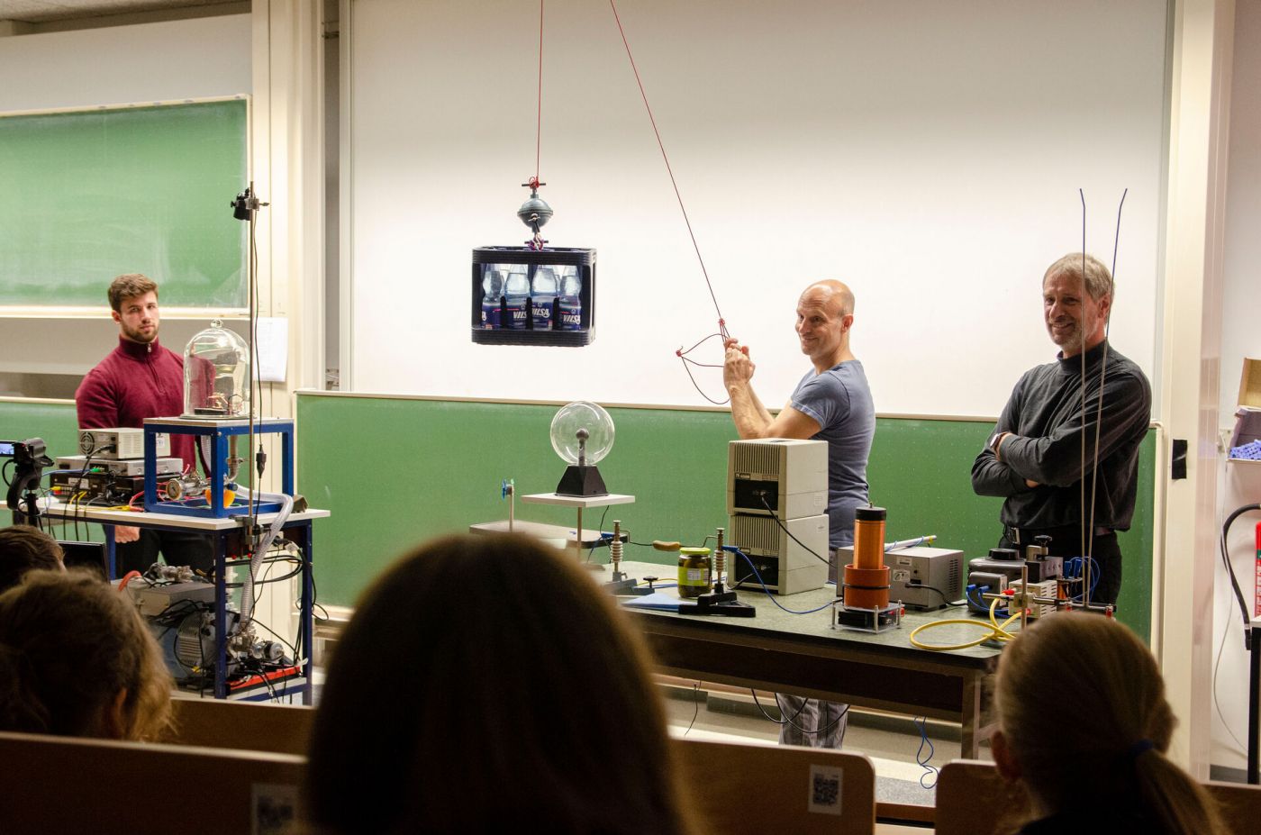 Drei Männer führen ein wissenschaftliches Experiment in einem Hörsaal durch. (Foto: FH Münster/Frederik Tebbe)