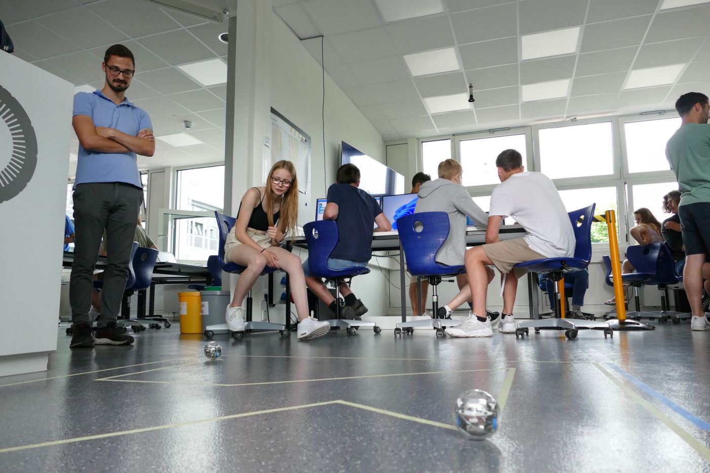 Schülerinnen und Schüler programmieren einen kugelförmigen Roboter im Labor. (Foto: FH Münster/Jana Bade)