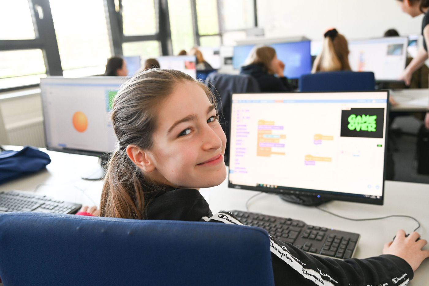 Ein Mädchen freut sich über die Arbeit am Computer.