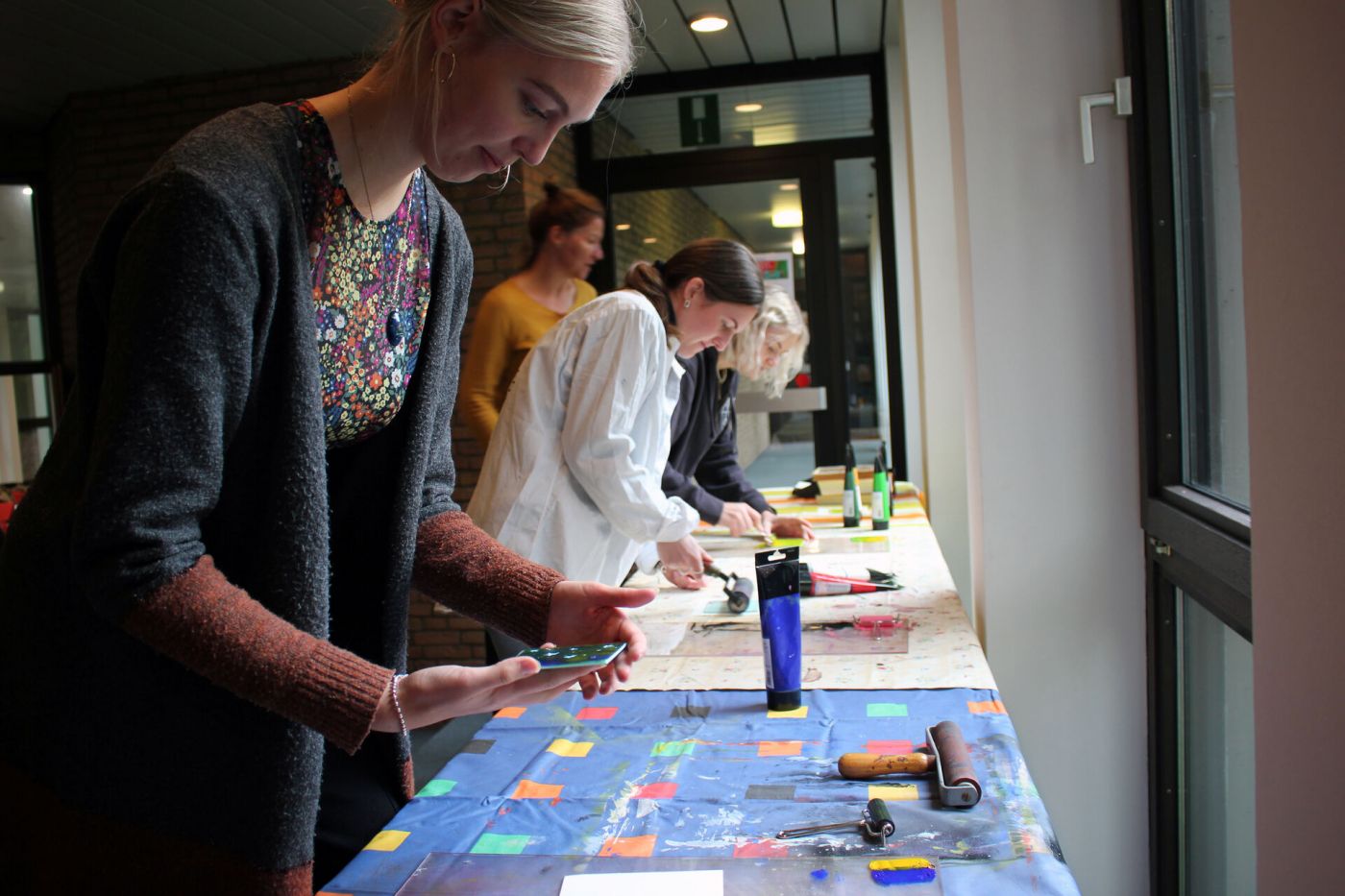 Drei Frauen bestreichen Linoldruckplatten mit Farbe. (Foto: FH Münster/Anna Thelen)