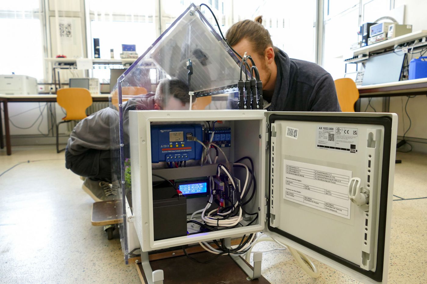 Zwei Männer arbeiten in einem Labor an einem experimentellen Gewächshaus. (Foto: FH Münster/Jana Bade)
