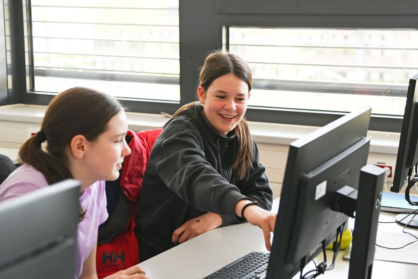 Zwei Mädchen arbeiten an einem Computer.