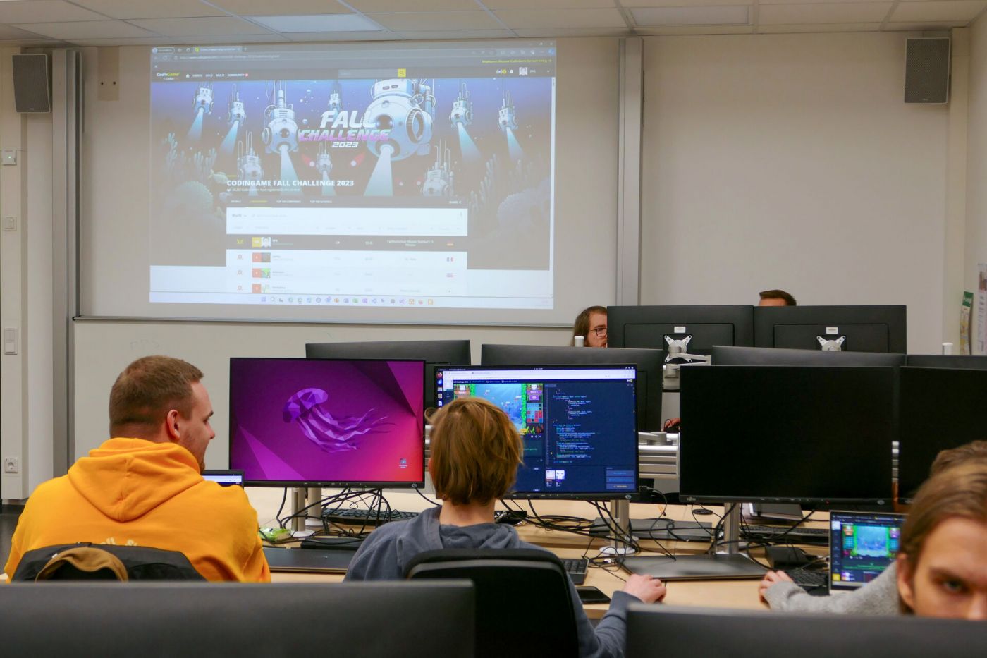 Mehrere Personen sitzen konzentiert am Computer, im Hintergrund sieht man auf einer Projektionsleinwand eine Webseite.  (Foto: Foto: FH Münster/Jana Bade)