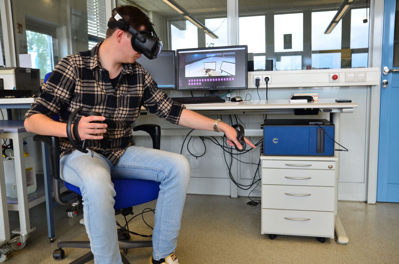 Ein Mann arbeitet im Labor mit einer VR-Brille. 