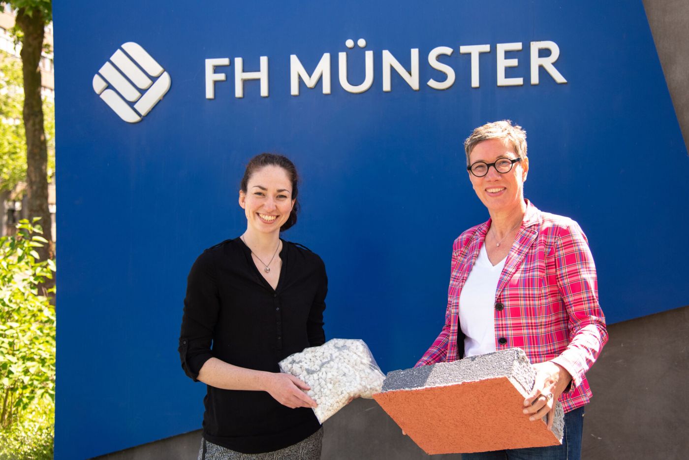 Zwei Frauen halten Baumaterialien in den Händen. (Foto: FH Münster/Michelle Liedtke)