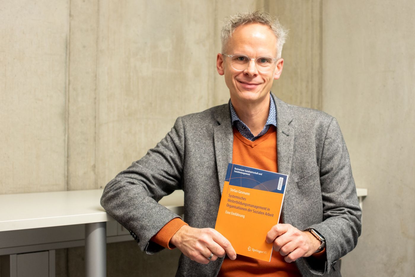 Ein Mann mit seinem neuen Fachbuch (Foto: FH Münster/Michelle Liedtke)