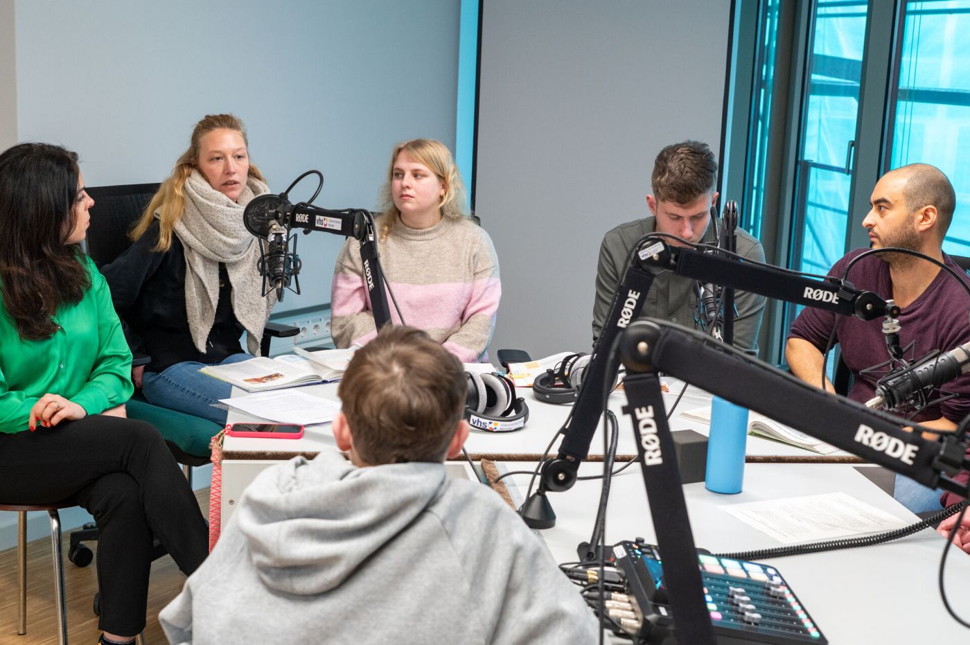 Schüler*innen, Studierende und ihre Professorin sitzen in einem Tonstudio und nehmen einen Podcast auf. (Foto: FH Münster/Michelle Liedtke)