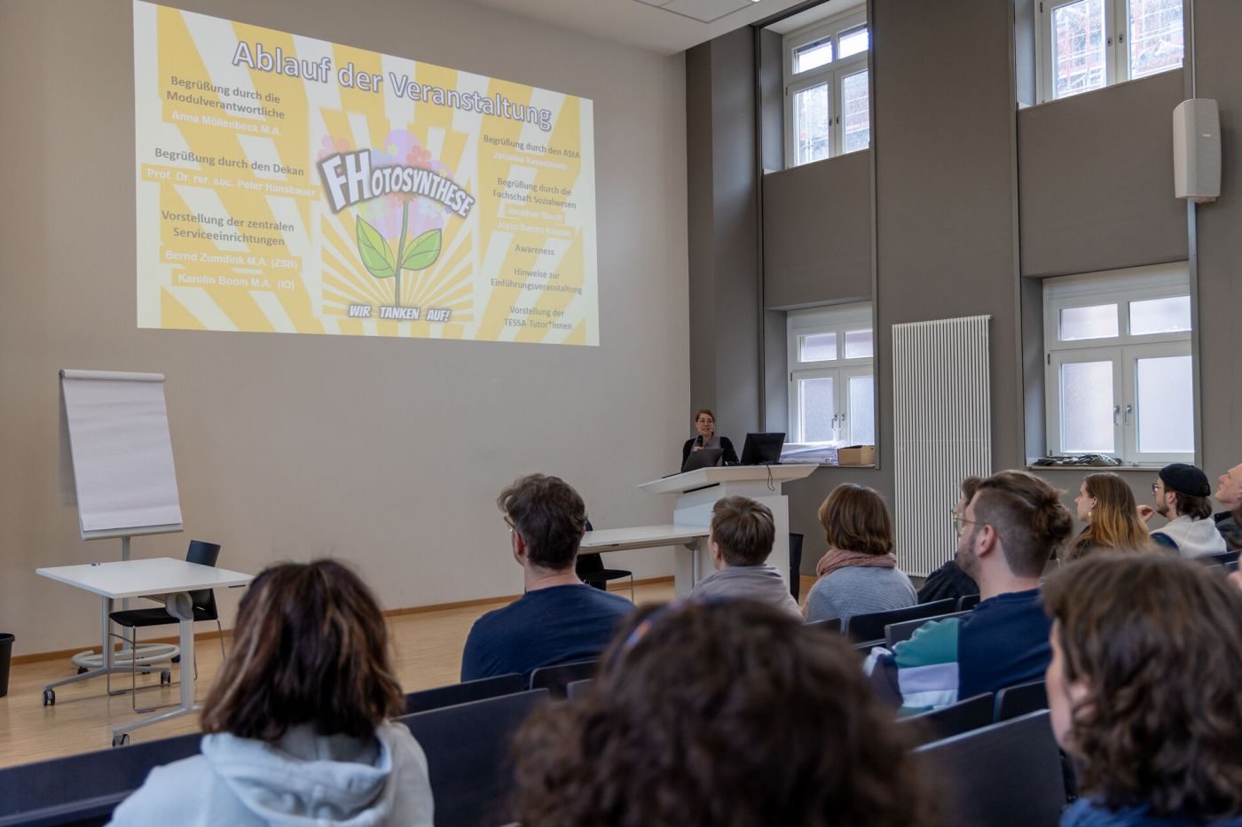 Eine Person steht an einem Pult und spricht zu einem Publikum in einem Hörsaal. (Foto: FH Münster/Anna Thelen)