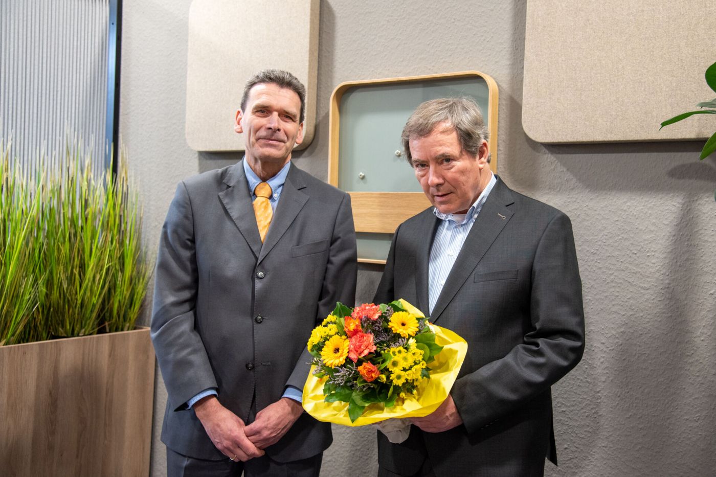 Zwei Männer, einer davon hält einen Blumenstrauß (Foto: FH Münster/Michelle Liedtke)