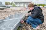Eine Schülerin arbeitet an einer Photovoltaikanlage.