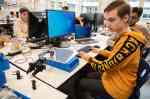 Schüler sitzen in einem Labor und bauen einen Roboterarm.  (Foto: FH Münster/Frederik Tebbe)
