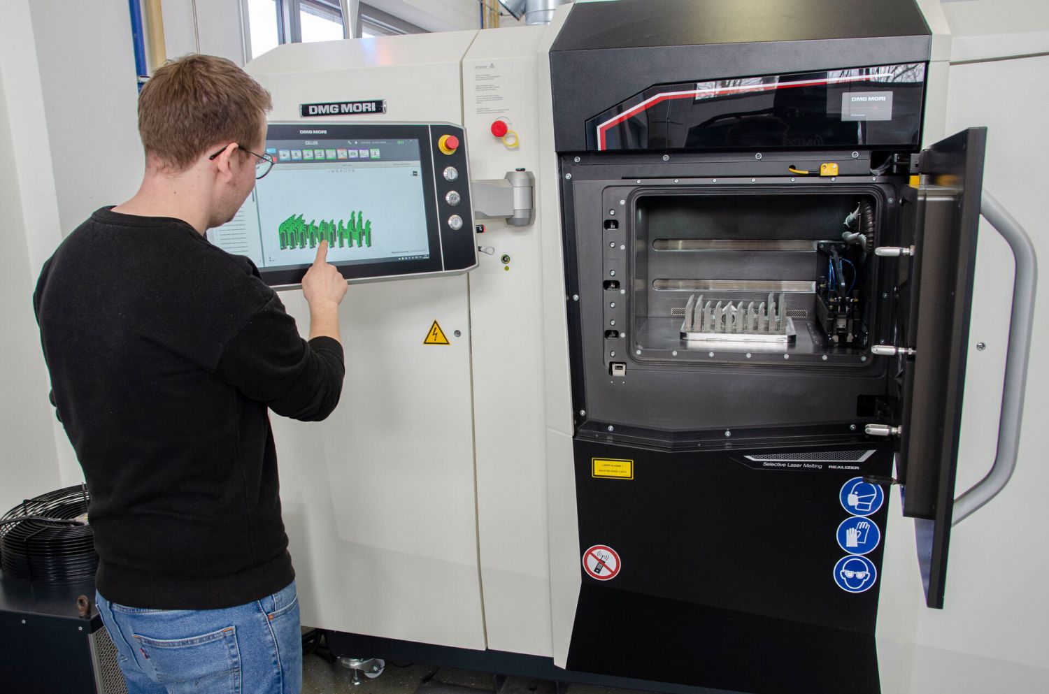 Ein Mann arbeitet an einem Metall-3D-Drucker.