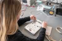 Eine Frau arbeitet mit einem Spritzgießwerkzeug zur Herstellung von Smartphone-Hüllen.
