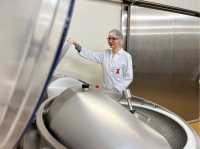 Das Foto zeigt Christina in Schutzkleidung vor einer Maschine, in der neue Produkte getestet werden.